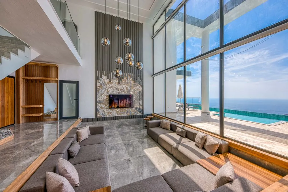 A living room with floor-to-ceiling windows and a sea view