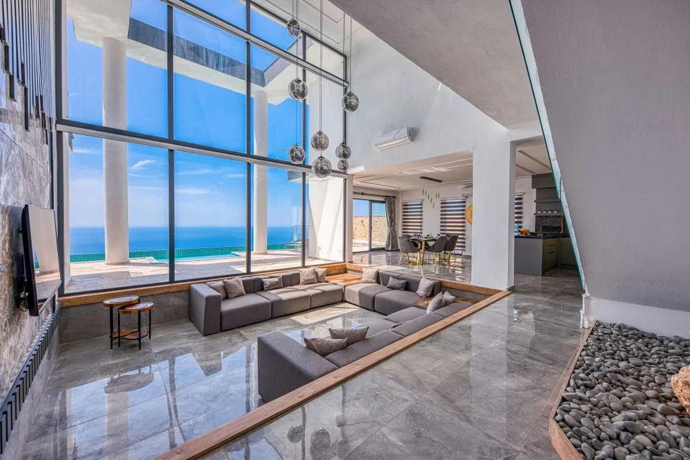A sitting room with glass walls and a view of the sea